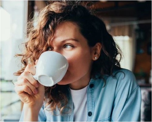 woman indulging in a cup of coffee